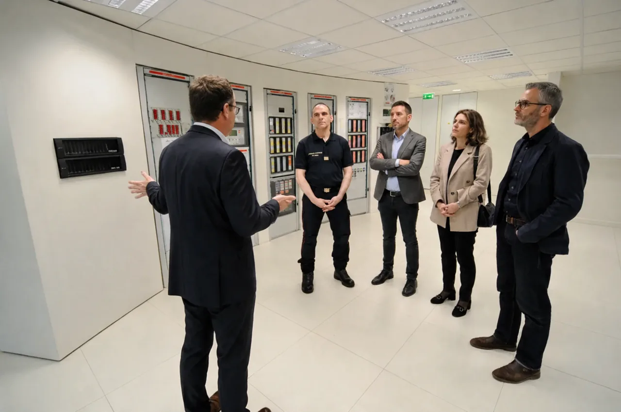 Visite d'une salle technique de sécurité : un professionnel présente les armoires de contrôle à un représentant des secours et à trois interlocuteurs