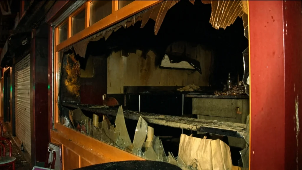Devanture fracassée et intérieur calciné du bar Au Cuba Libre à Rouen après l'incendie