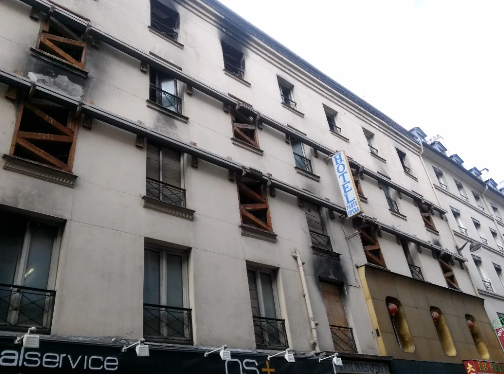 Façade de l'ancien hôtel Paris-Opéra rue de Provence en 2015, dix ans après l'incendie, baies obstruées par des planches