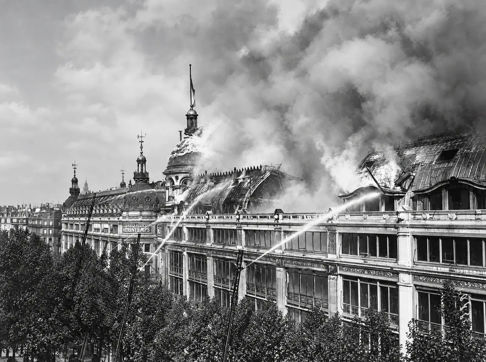 L'embrasement des toitures et l'attaque des lances lors de l'incendie des Grands Magasins du Printemps sur le boulevard Haussmann